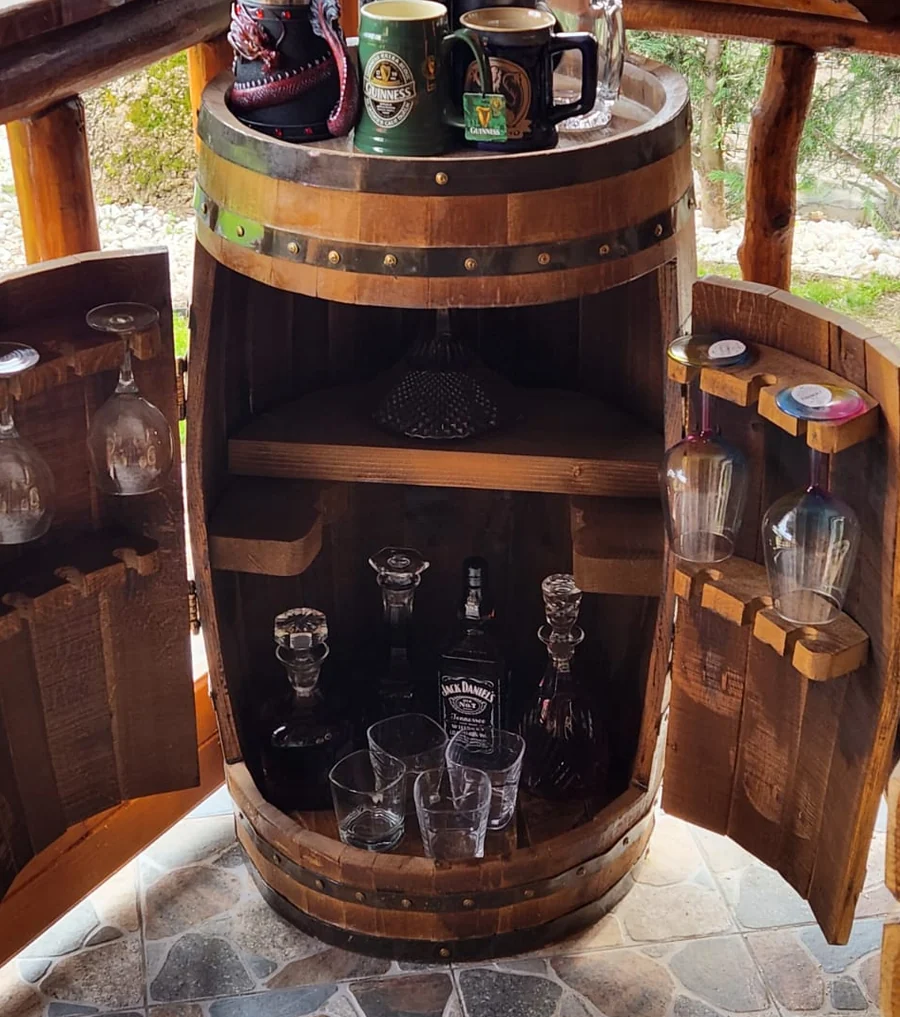Butoiul de lemn folosit ca bar, deschis, cu sticle și pahare